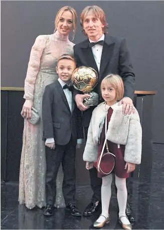  ?? AFP ?? Real Madrid and Croatia midfielder Luka Modric poses with the Ballon d’Or trophy and his family in Paris.