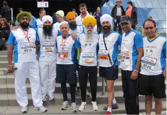  ??  ?? The remarkable Fauja Singh (centre), with members of Sikhs in the City. Harmander Singh is at the back, in the green beanie