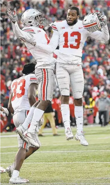  ?? AP ?? Ohio State CBs Tyreke Johnson (13) and Kendall Sheffield celebrate after comeback win over Maryland.