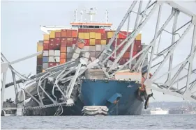  ?? ?? The steel frame of the Francis Scott Key Bridge sits on top of the container ship Dali after the bridge collapsed, Baltimore, Maryland, yesterday. PHOTO: AFP