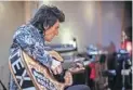  ??  ?? Ronnie Wood gets in some practice on a gift from the Buddy Holly Educationa­l Foundation.
Eagle Rock Films