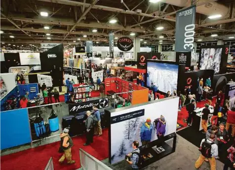  ?? Bloomberg ?? Attendees walk on the exhibition floor of the 2017 Outdoor Retailers Winter Market Show in Salt Lake City on Wednesday. Brick-and-mortar retailers are struggling to attract shoppers to their stores as online competitor­s such as Amazon lure away...