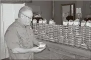  ?? Doug Walker / Rome News-Tribune ?? Larry Lassiter, owner of the Herb Shop On Broad in Rome, holds one of the small containers of kratom, a natural herbal substance that has generated some controvers­y in the past year but is still perfectly legal as a natural painkiller.