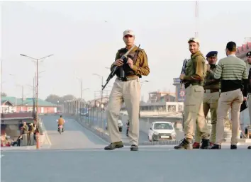  ?? Reuters ?? Policemen stand guard on a road in Srinagar on Thursday.—