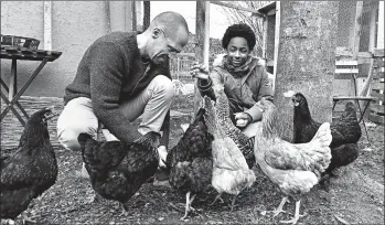  ?? MARTIN MEISSNER/AP ?? Dirk Gratzel and neighbor kid Elias feed chickens in Stollberg. Gratzel’s emissions were over twice the German average.