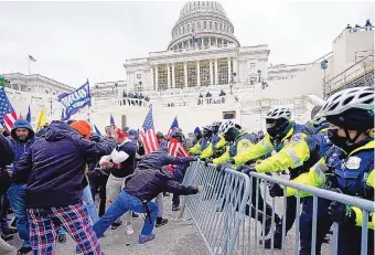  ?? JULIO CORTEZ/ASSOCIATED PRESS ?? Protesters turned rioters try to break through a police barricade outside the Capitol building. Officers were ordered not to draw their weapons. Five people died during or after the riot.