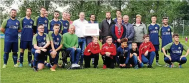  ?? FOTO: VEREIN ?? Die Fußballer der SG Emleben können sich auf ein nagelneues Spielfeld freuen. Thomas Eifert (Mitte, dunkelblau­es Jackett) vom Landesspor­tbund brachte für die Sportplatz-Sanierung Fördermitt­el über . Euro in Emleben vorbei.