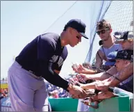  ?? Lynne Sladky / Associated Press ?? The New York Yankees’ Aaron Judge signs autographs before a spring training game against the Philadelph­ia Phillies on Friday in Clearwater, Fla.