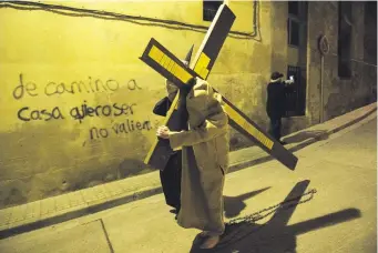  ?? ?? “Silencio del Santísimo Cristo del Rebate”, un penitente carga una cruz en Tarazona, España.