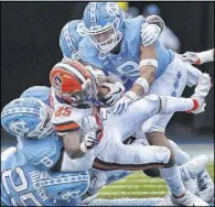  ?? The Associated Press ?? Robert Willett
North Carolina’s defense swarms Syracuse running back Jawhar Jordan in the fourth quarter of the Tar Heels’ 31-6 win Saturday at Kenan Memorial Stadium.