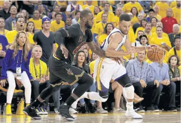  ?? AFP ?? The Warriors’ Stephen Curry, right, drives with the ball against the Cavaliers’ LeBron James.