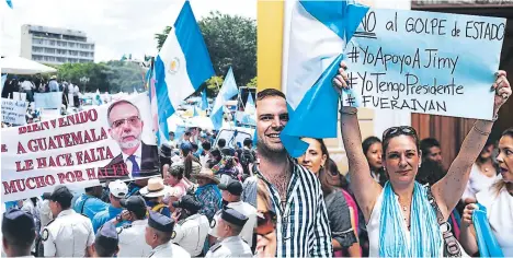  ?? FOTOS: AP/AFP ?? un yrupo de simp“tiz“ntes lley““l“pl“z“centr“l de l“ciud“d de gu“tem“l“p“r“mostr“r “poyo “Vel”squez. un“mujer se presentó en el p“l“cio leyisl“tivo con un“p“nc“rt“en u“vor del “ctu“l presidente, Jimmy mor“les.