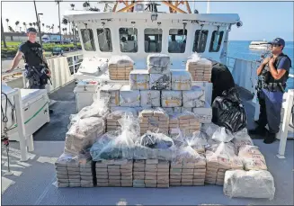  ?? CARLSON/ASSOCIATED PRESS FILE PHOTO] [CHRIS ?? In this Aug. 29 file photo, members of the Coast Guard stand near seized cocaine in Los Angeles.