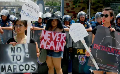  ?? AFP ?? Protesters display placards during a rally at the Heroes Cemetery to protest against the hero’s burial accorded the late Philippine dictator Ferdinand Marcos as the nation marks the 31st anniversar­y of the People Power revolution that toppled the...