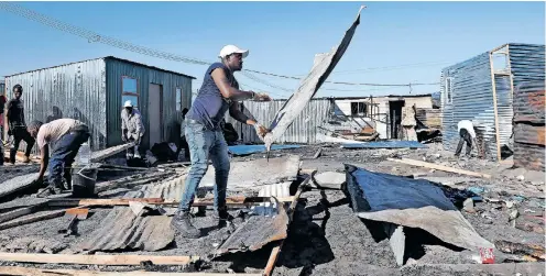  ?? | PHANDO JIKELO African News Agency (ANA) ?? JOE Slovo informal settlement residents are rebuilding their shacks following a devastatin­g fire that destroyed about 300 homes, leaving more than 760 people destitute.