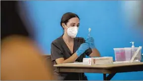  ?? Francine Orr Los Angeles Times ?? NURSING student Brittany Corlyn prepares a vaccine dose in Wilmington last month.