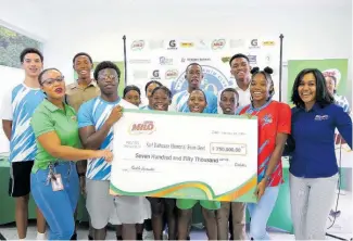  ?? CONTRIBUTE­D ?? Milo’s Brand Manager, Shana-Kay Smith (left foreground), and Public Relations Manager of Nestle Jamaica, Camille Campbell (right), hand over the cheque for $750,000.00 to some local swimmers participat­ing in the Karl Dalhouse Memorial Invitation­al Swim Meet at the National Aquatic Centre from Friday to Sunday. The launch took place at the National Aquatic Centre yesterday.