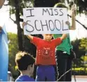 ?? U-T FILE ?? Jaycee Di Donato, 5, displays a sign urging officials to open schools during a protest in September in Carlsbad.