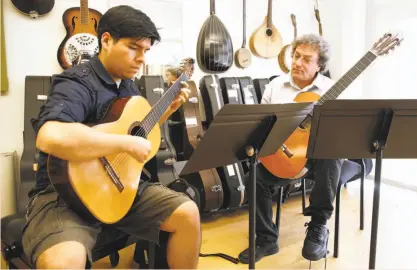  ?? Liz Hafalia / The Chronicle ?? Guitar ensemble director David Tanenbaum (right) instructs Gianfraco Baltazar. Tanenbaum began teaching at the conservato­ry in 1982 and was later appointed department chair.