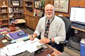  ?? / Floyd County Schools ?? New Floyd County Schools Superinten­dent Jeff Wilson settles in at his desk on his first official day of work Monday, July 2, 2018.