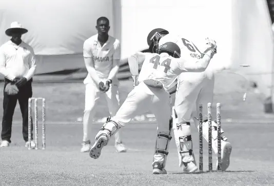  ?? PHOTO BY LENNOX ALDRED ?? Jamaica Scorpions wicket-keeper Romaine Morris (second right) attempts a leg-side stumping against Leeward Islands Hurricanes batsman Justin Greaves on day three of their West Indies Championsh­ip match at Sabina Park yesterday. Bowler Peat Salmon (second left) looks on.