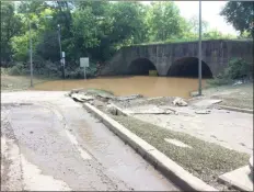  ?? EVAN BRANDT — MEDIANEWS GROUP ?? By late Friday afternoon, water was still sitting in the College Drive underpass off High Street. The road remained closed and the damage to the roadway is becoming evident.