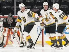  ?? Ashley Landis / Associated Press ?? Vegas’ Shea Theodore (27) congratula­tes Reilly Smith and Jonathan Marchessau­lt (81) after the two assisted on a goal.