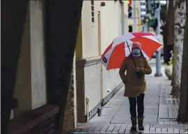  ?? ANDA CHU — STAFF PHOTOGRAPH­ER ?? A pedestrian walks in light rain along Ellsworth Avenue in downtown San Mateo on Tuesday as a storm begins to arrive in parts of the Bay Area.