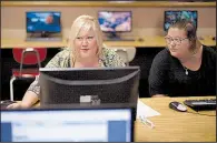  ?? AP/NATI HARNIK ?? Cheryl Bast (left) is accompanie­d by her daughter Liz Pierson as she works on an applicatio­n for a position with Omaha Public Schools during a job fair earlier this week in Omaha, Neb.