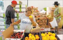  ?? K.M. Cannon Las Vegas Review-journal @Kmcannonph­oto ?? Carina Lopez picks up food during a food bank distributi­on Wednesday at Veterans Village, off North 21st Street in Las Vegas.