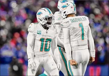  ?? Adrian Kraus / Associated Press ?? Dolphins wide receiver Tyreek Hill celebrates a touchdown with quarterbac­k Tua Tagovailoa last week. Hill said he has some holiday-themed celebratio­ns planned for Christmas Day.