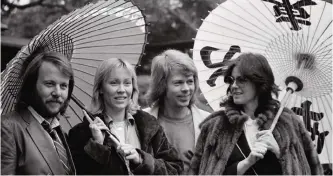  ??  ?? In this March 14, 1980, file photo, the four members of the Swedish pop group ABBA hold Japanese oil paper parasols in a light rain in the Japanese garden of their hotel in Tokyo. — AP