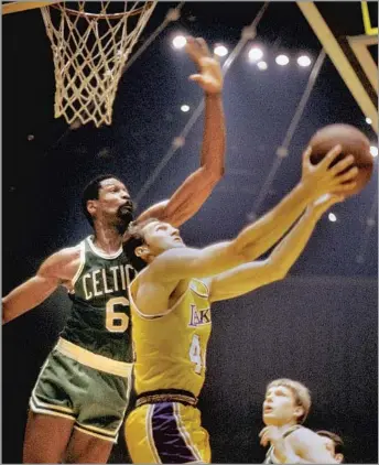  ?? Focus On Sport Getty Images ?? JERRY WEST tries a reverse layup against Bill Russell in the late 1960s. The Lakers legend considered Russell a friend and still has a compliment­ary framed quote from Russell hanging in his bathroom.