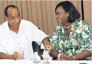  ?? SERJU PHOTO BY CHRISTOPHE­R ?? Michael Lee-Chin seems to be providing details of the $60-million bailout for small farmers who cultivate Blue Mountain Coffee, much to the delight of Juliet Holness, member of parliament for St Andrew East Rural, during a press briefing at the Ministry of Industry, Commerce, Agricultur­e and Fisheries’ St Lucia, New Kingston, office.