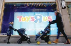  ??  ?? People pass by Toys R Us store at Times Square in New York. — Reuters