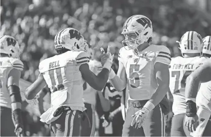  ?? MICHAEL REAVES / GETTY IMAGES ?? Wisconsin quarterbac­k Graham Mertz celebrates a touchdown with receiver Skyler Bell in the first quarter against Northweste­rn last Saturday. “We started off quick throwing. I enjoyed it,” Mertz said.