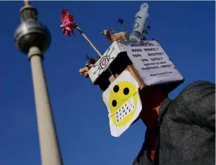  ??  ?? ABOVE LEFT: A lockdown protester in Alexanderp­latz, Berlin. ABOVE RIGHT: German singer Xavier Nadoo is one of the celebritie­s spreading Covid-19 conspiracy theories.