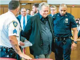  ?? STEVEN HIRSCH/NEW YORK POST ?? Former White House strategist Steve Bannon, center, is escorted Thursday into the courtroom in Manhattan State Supreme Court to be arraigned.