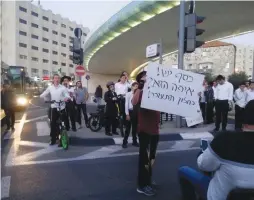  ?? (Ido Barak) ?? A SMALL GROUP of protesters blocks the main exit and entrance into Jerusalem on Wednesday as they demonstrat­ed in favor of raising disability allotments.