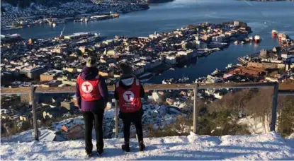  ??  ?? FRIVILLIGE: Guro Karlstad og Harnit Kaur var med å rigge til bursdagsfe­sten i Trollskoge­n, og tar seg en liten pause for å beundre utsikten fra Fløyen.