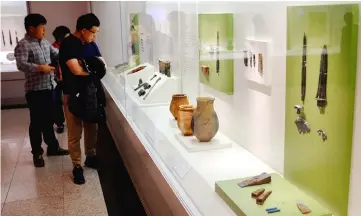  ??  ?? Visitors at Seoul’s National Museum of Korea examine a display of artefacts from Gojoseon, the first unified Korean kingdom, said to have lasted from 2333 BCE to 108 BCE, in Seoul. — Reuters photo