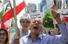  ?? Reuters; EPA ?? Top, health workers attend to patients at a field hospital in Bebnine, northern Lebanon. Above, doctors and nurses protest in front of the central bank in Beirut