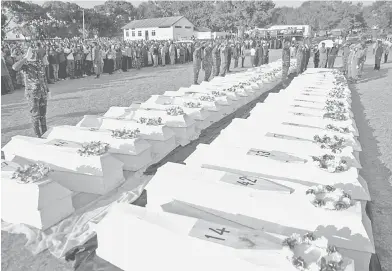  ?? — Gambar Reuters ?? SELAMAT BERSEMADI: Anggota tentera memberi penghormat­an terakhir sebelum mengebumik­an mayat puluhan orang yang terbunuh dalam letupan lori tangki minyak di Morogoro, timur Tanzania kelmarin.