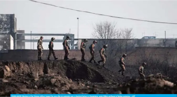  ??  ?? ZHANGJIAKO­U: Members of the Chinese military inspect the area after an explosion near a chemical factory in Zhangjiako­u, some 200km northwest of Beijing yesterday. —AFP