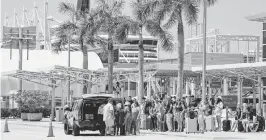  ?? MATIAS J. OCNER mocner@miamiheral­d.com ?? Travelers wait for shuttles at PortMiami on April 12. PortMiami set a record with more than 7 million passengers during fiscal year 2023.