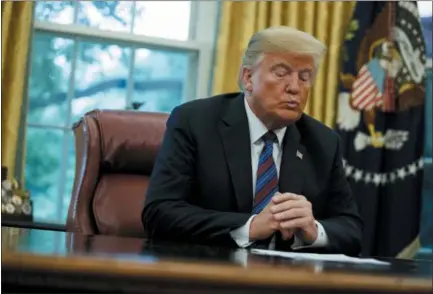  ?? EVAN VUCCI — THE ASSOCIATED PRESS ?? President Donald Trump talks on the phone with Mexican President Enrique Pena Nieto, in the Oval Office of the White House on Monday in Washington.