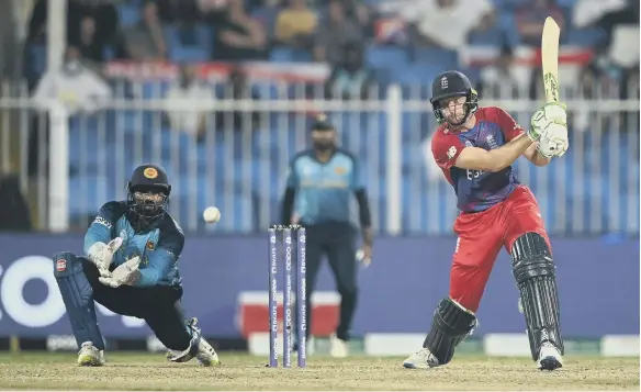  ?? ?? England’s Jos Buttler plays a shot as Kusal Perera, of Sri Lanka, looks on during the ICC Men’s T20 World Cup match.