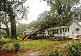  ??  ?? A downed tree rests on a house during the passing of Hurricane Florence in the town of Wilson, North Carolina, US, on Friday.