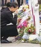  ?? MATT ROURKE/ASSOCIATED PRESS ?? A woman pays her respects Monday at a makeshift memorial to Saturday’s deadly shooting at a synagogue in Pittsburgh.