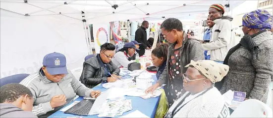  ??  ?? People throng a medical insurance stand during the Insurance Market Day along 8th Avenue on Friday. — Picture by Dennis Mudzamiri